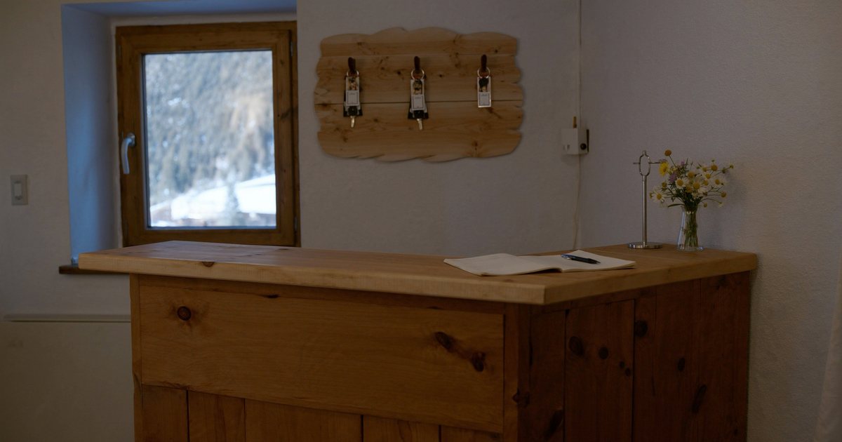 Schlüsselbrett und Gästebuch auf einem Holztresen in einem kleinen Ferienhaus